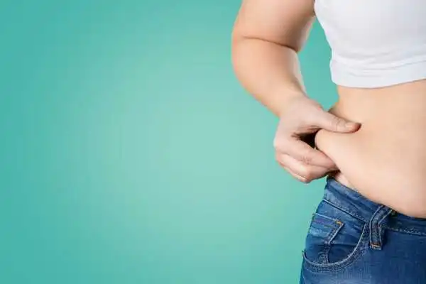 Image of woman pinching her love handles to show weight gain Springs Mire